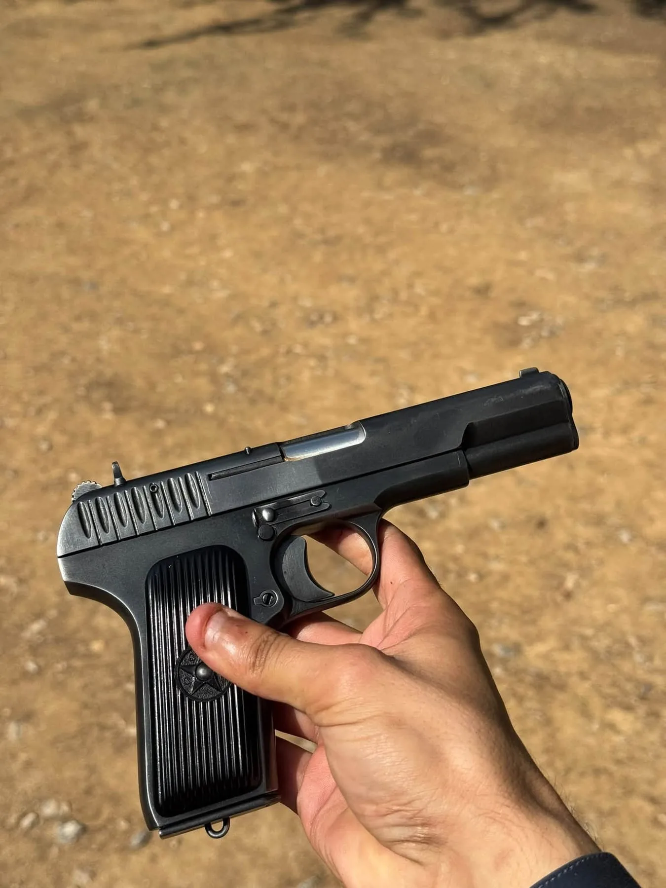 A TT-pattern .30 bore pistol held in hand