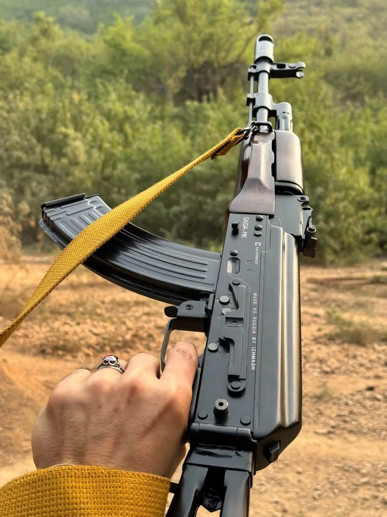 An AK-pattern rifle with a folding stock and a yellow sling