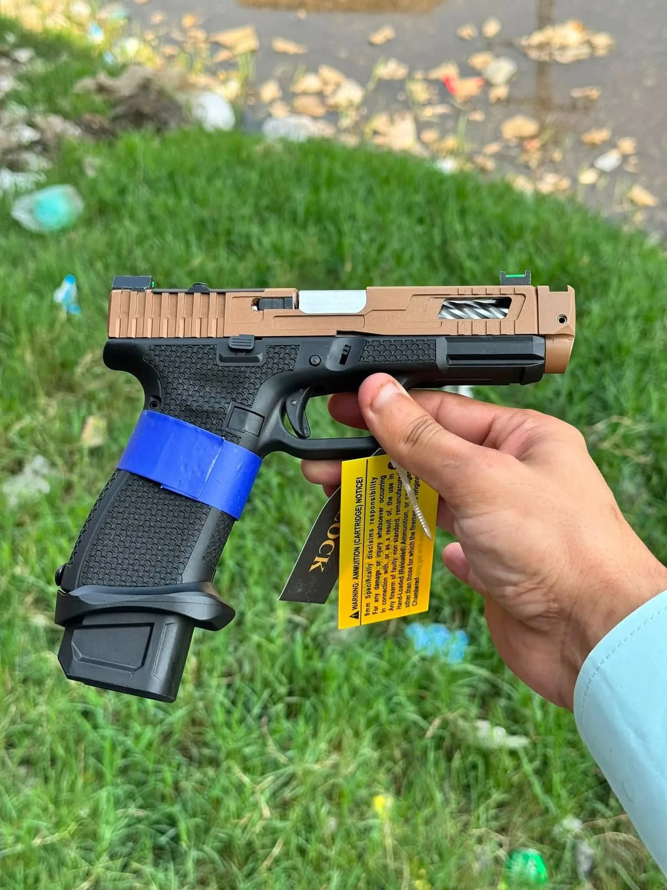 A Glock pistol with a bronze-finish slide