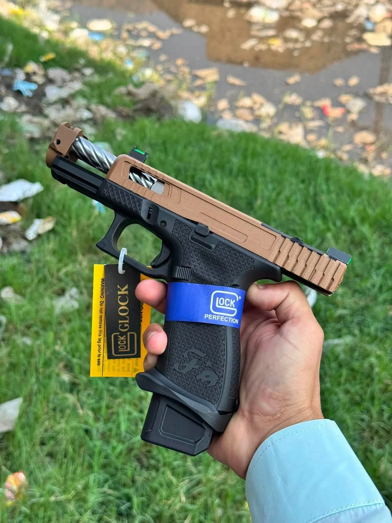 A Glock pistol with a bronze-finish slide and its magazine