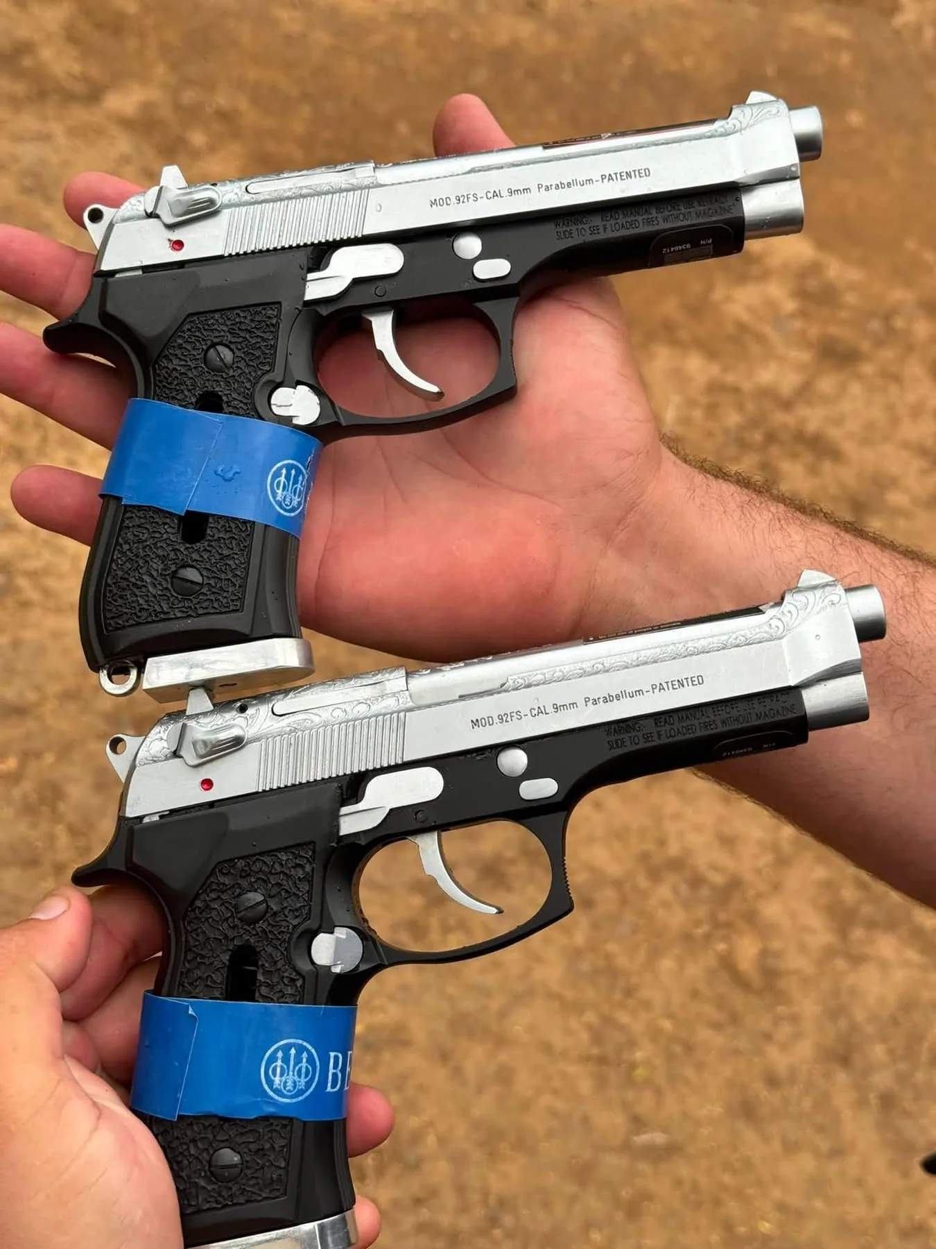 Two two-tone Beretta 92-pattern pistols