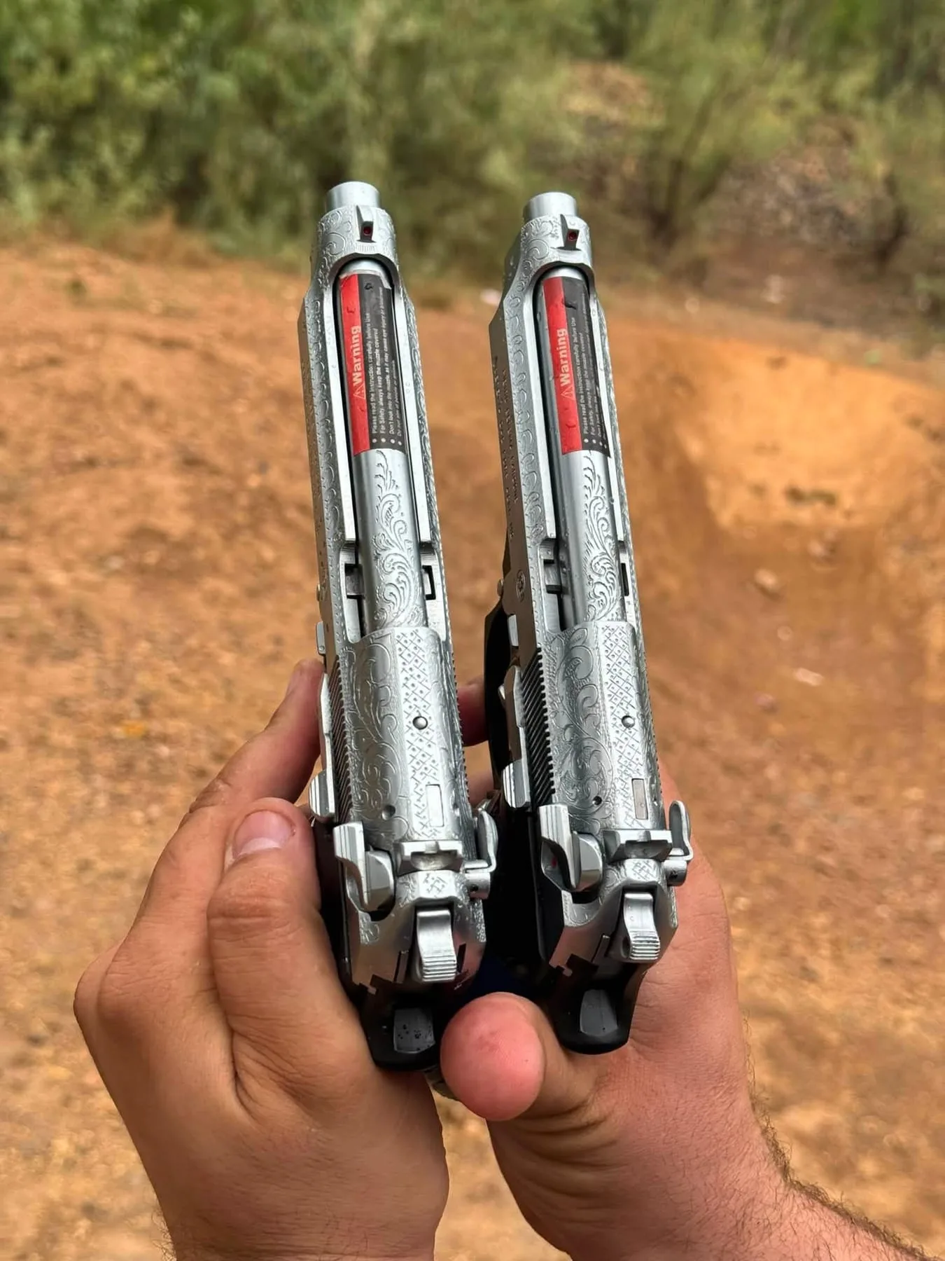 Two two-tone pistols seen from above