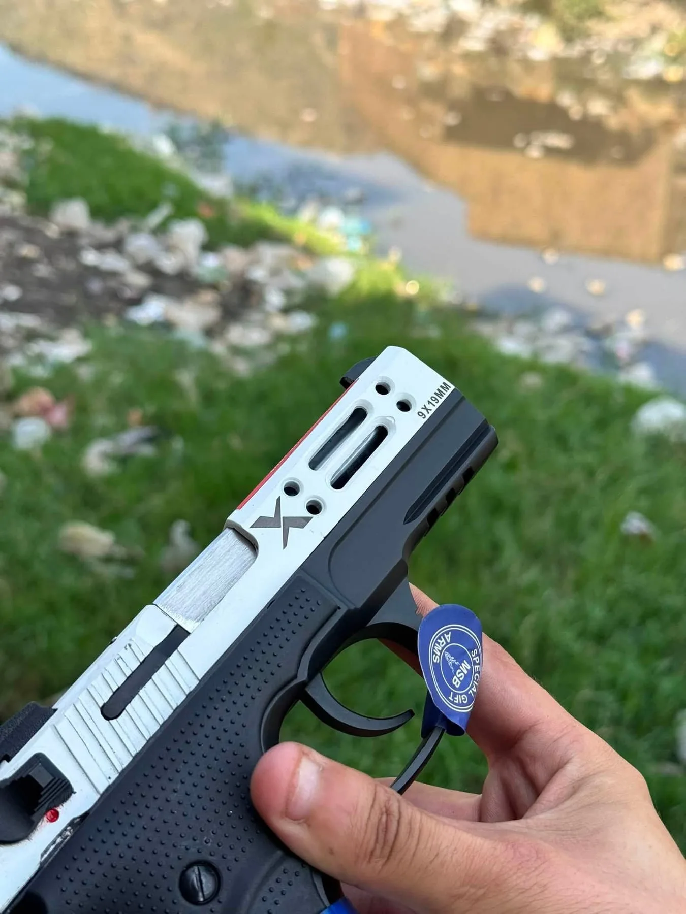 A two-tone pistol with a cut-out slide