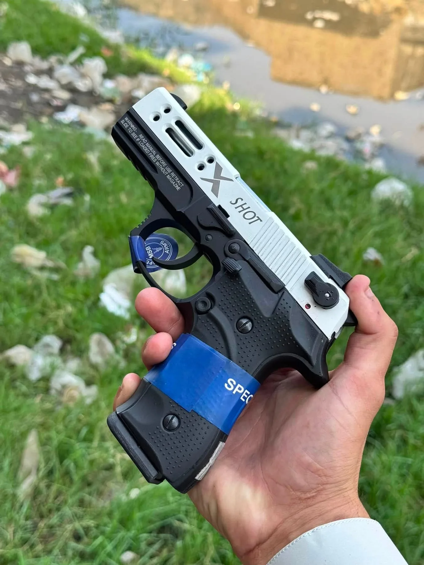 A two-tone compact pistol held in hand