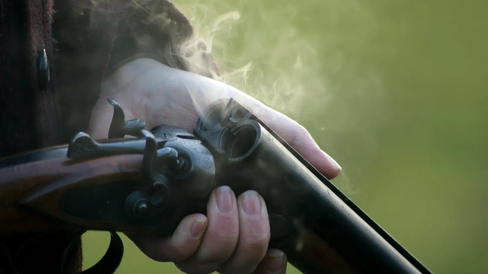 A person holding a pump-action shotgun